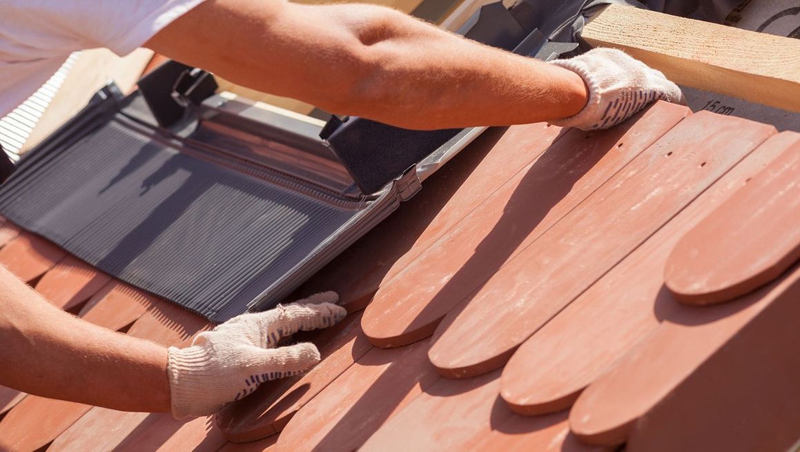 Roofer fitting roof tiles